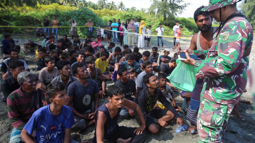 ১০ ডিসেম্বর আকেহ প্রদেশে এসে পৌঁছানো রোহিঙ্গা পুরুষদের তথ্য সংগ্রহ করছেন সামরিক বাহিনীর সদস্যরা। ছবি: রয়টার্স
