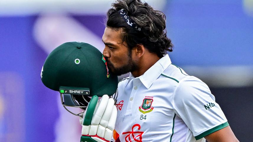 Bangladesh's captain Najmul Hossain Shanto kisses his helmet as he celebrates after scoring a century 
